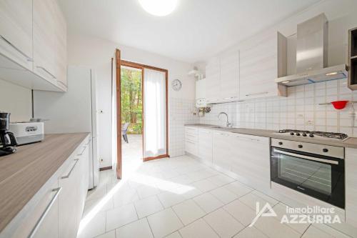 a white kitchen with white appliances and a window at Casa Ruby - Immobiliare Azzurra in Lazise