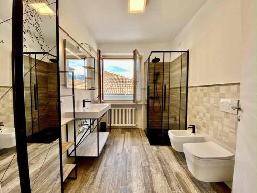 a bathroom with two sinks and a shower and two toilets at Casa del Tempo Irma Tassullo Ospitar in Tassullo