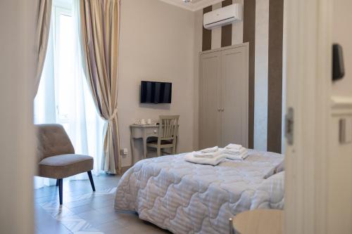 a bedroom with a bed and a chair and a table at DIMORA LE PIETRE DEL MARE in Pizzo