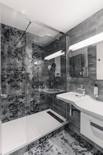 a bathroom with a shower and a sink at Le Thalassa Hôtel & Spa in Camaret-sur-Mer