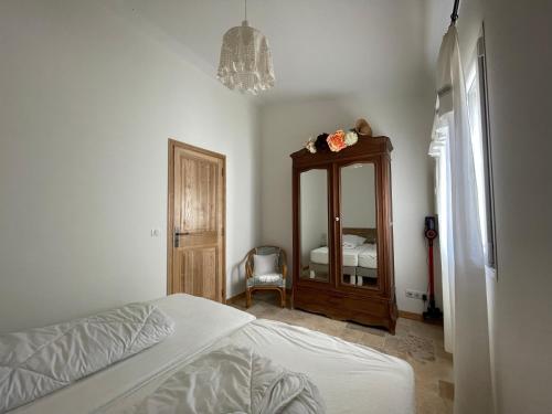1 dormitorio con cama, tocador y espejo en Douceur d'Olive - Maison avec piscine privée, en Fox-Amphoux