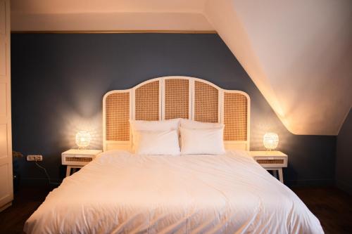 ein Schlafzimmer mit einem großen weißen Bett mit zwei Lampen in der Unterkunft Vakantiewoning De Pastorie in Boven-Leeuwen