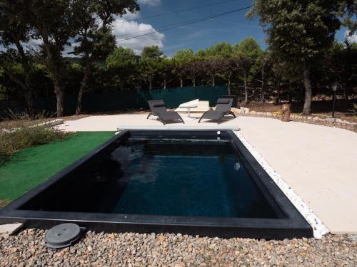 - une piscine dans une cour avec 2 chaises dans l'établissement Douceur d'Olive - Maison avec piscine privée, à Fox-Amphoux