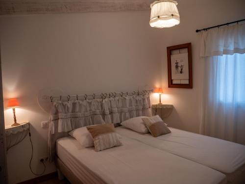 une chambre avec un lit blanc avec deux oreillers dans l'établissement Fleur de Romarin - Avec piscine privée, à Fox-Amphoux