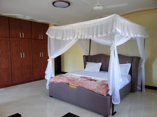 a bedroom with a bed with a canopy at Bigodi Community Homestay in Kamwenge