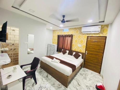 a bedroom with a bed and a desk and a chair at Hotel 7 star in Indore