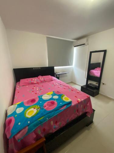 Schlafzimmer mit einem Bett mit einer roten Bettdecke in der Unterkunft Don carmelo in Valledupar