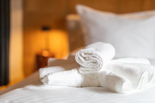 a pile of white towels on a bed at SAUERLAND CHALETS - "Die Chalets Herzenssache" in Winterberg