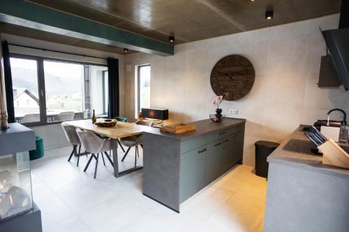 a kitchen with a counter and a table with chairs at SAUERLAND CHALETS - "Die Chalets Herzenssache" in Winterberg