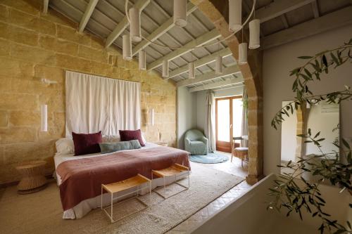 a bedroom with a large bed in a brick wall at Amagatay Luxury Boutique Hotel - Adults Only in Alaior