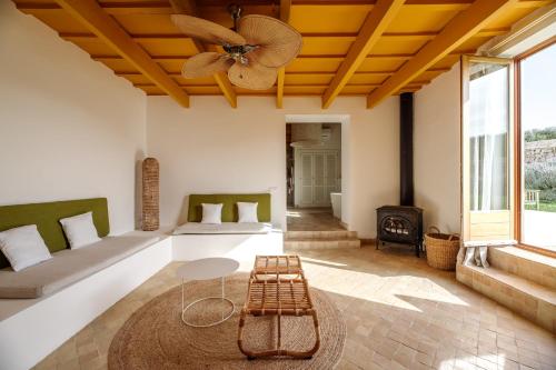 a living room with two beds and a ceiling fan at Amagatay Luxury Boutique Hotel - Adults Only in Alaior