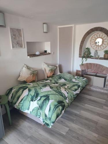 une chambre avec un lit avec une couverture verte dans l'établissement Studio 30 m 2 avec terrasse et coin détente, à Cagnes-sur-Mer