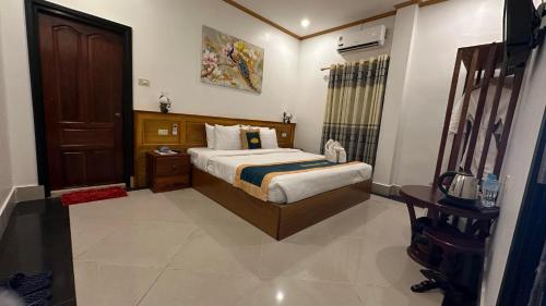 a bedroom with a bed and a wooden door at Villa Mahasok hotel in Luang Prabang