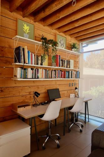 an office with a wooden wall with a desk and chairs at Casa Mirador Roca in Matanzas