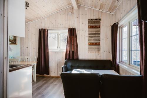 a living room with a couch and a kitchen at FOSSEN CAMPING in Geiranger