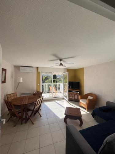 un salon avec une table et un canapé dans l'établissement Appartement Clim Terrasse, au Lavandou