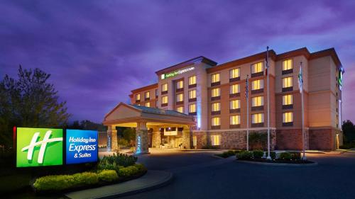 a hotel building with a sign in front of it at Holiday Inn Express & Suites Huntsville by IHG in Huntsville