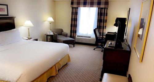 um quarto de hotel com uma cama e uma sala de estar em Holiday Inn Express & Suites Huntsville, an IHG Hotel em Huntsville