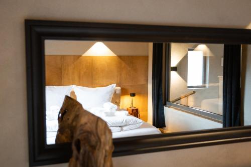 a mirror reflection of a bed in a hotel room at SAUERLAND CHALETS - "Die Chalets Herzenssache" in Winterberg