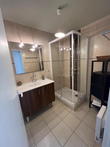 une salle de bain avec un lavabo et une douche dans l'établissement Appartement Clim Terrasse, au Lavandou