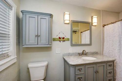 une salle de bain avec un lavabo, des toilettes et un miroir dans l'établissement Seaside Retreat Cottages #1, à Clearwater Beach