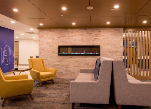 a waiting room with chairs and a fireplace at Holiday Inn Express & Suites Huntsville by IHG in Huntsville