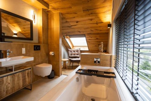 a bathroom with a tub and a sink at SAUERLAND CHALETS - "Die Chalets Herzenssache" in Winterberg