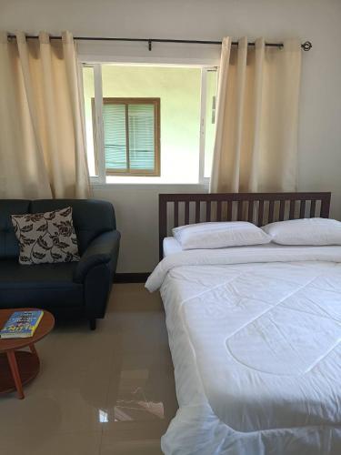 a bedroom with a bed and a couch and a window at Wasin House One Bedroom - Maenum in Mae Nam