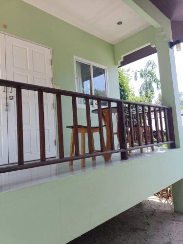 a balcony of a house with a wooden railing at Wasin House One Bedroom - Maenum in Mae Nam