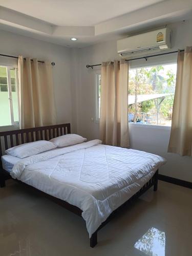 a large bed in a bedroom with a window at Wasin House One Bedroom - Maenum in Mae Nam