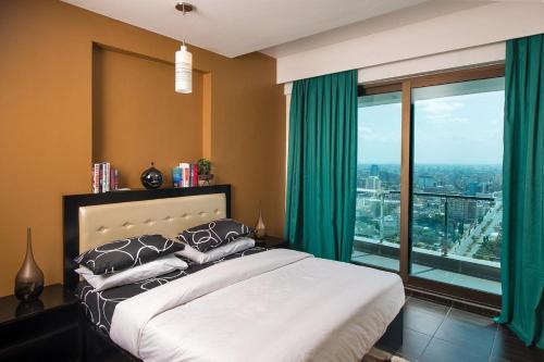 a bedroom with a bed and a large window at Uhuru Heights Studio Apartment in Dar es Salaam
