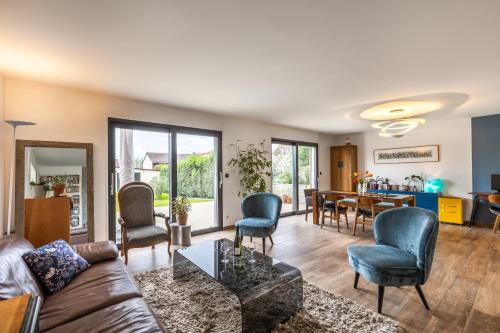 un salon avec un canapé, des chaises et une table dans l'établissement Magnifique maison avec jardin et salle de jeux proche Paris, à Villejuif