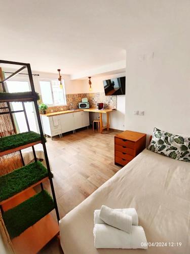 a bedroom with a large bed and a kitchen at Seixal Bay Village - Estúdio Vista Piscina in Seixal