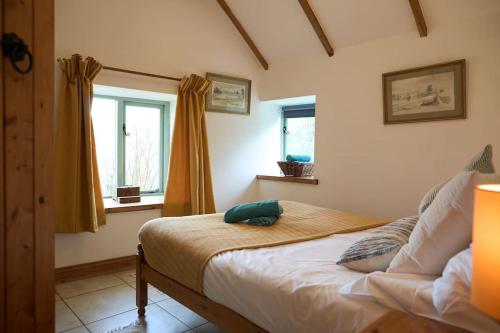 une chambre avec un lit avec un oreiller vert dessus dans l'établissement Noxon Pond Cottage, à Clearwell