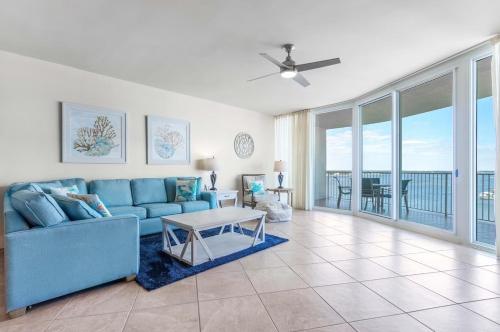 a living room with a blue couch and a table at Caribe Resort Unit C1108 in Orange Beach