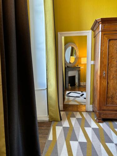 a room with a bedroom with a mirror and a dresser at La maison au cèdre in Marsac-sur-lʼIsle
