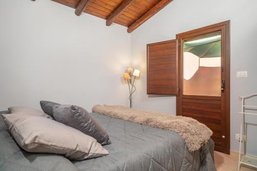 - une chambre avec un lit et des oreillers dans l'établissement Le 100 Sculture Apartment, à Belpasso