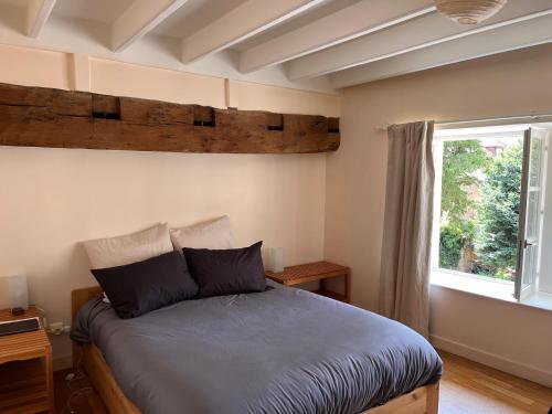 1 dormitorio con cama y ventana en Cosy Jacobins, en Langres