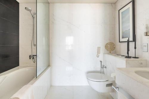 ein weißes Bad mit einem WC und einem Waschbecken in der Unterkunft Frank Porter - Kempinski Central Avenue in Dubai