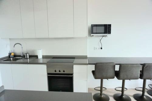 Edif La Luz Apartment No 4 with big private terrace في لوس سيلوس: مطبخ مع حوض و كرسيين بار
