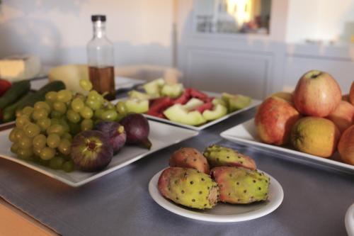 a table with three plates of fruit on it at Artina Nuovo in Marathopolis