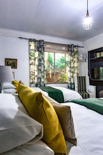 a bedroom with two beds and a large window at Waters on Willows in Pretoria