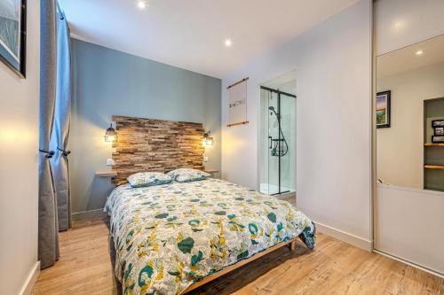 a bedroom with a bed and a brick wall at Appartement du Théâtre Morlaix in Morlaix