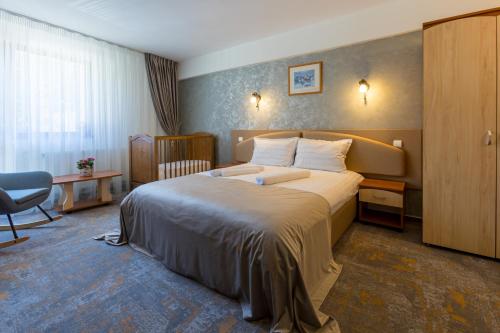 a hotel room with a bed and a chair at LaRotonde in Predeal