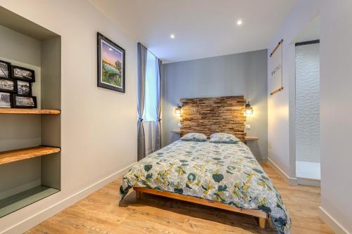 a bedroom with a bed and a brick wall at Appartement du Théâtre Morlaix in Morlaix