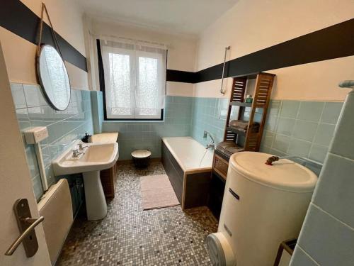 La salle de bains est pourvue d'un lavabo, d'une baignoire et de toilettes. dans l'établissement Appartements « La Parenthèse », à Wissembourg
