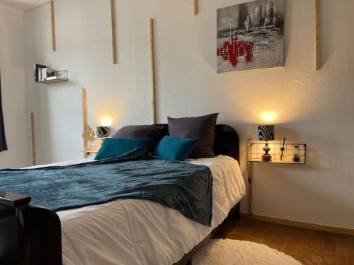 une chambre avec un grand lit avec des oreillers bleus dans l'établissement Appartements « La Parenthèse », à Wissembourg