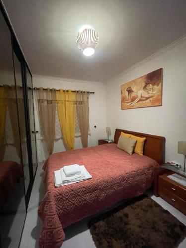 a bedroom with a bed with a red bedspread at Quarto Suite Relaxante in Almada