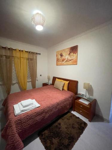 um quarto com uma cama com uma colcha vermelha em Quarto Suite Relaxante em Almada
