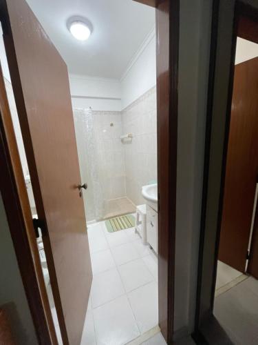 a bathroom with a shower and a toilet and a door at Quarto Suite Relaxante in Almada